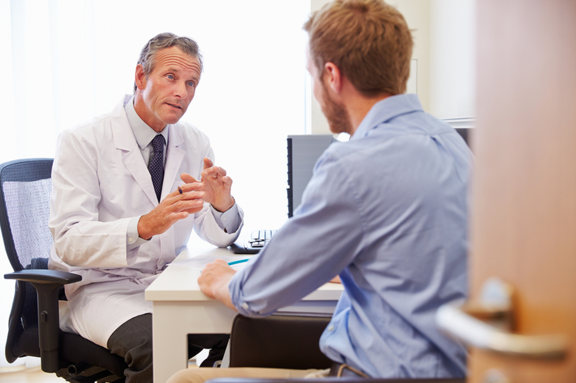 Medical doctor discussing information with a male patient.